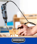 Powerful 1.2 Amp Rotary Tool Kit with 62 Accessories and Carrying Case being used for wood engraving on a workbench