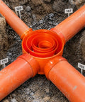 Heavy Duty Electrical Conduit Pipe Connector For A Rock Solid Thread Lock And No Sweat Setup On Outdoor Junction Boxes with orange pipes.