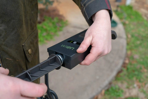 Outdoors WiFi Smart Yard Stake Plug With Three Weatherproof Outlets And Six Foot Cord Straight Up Easy Smartphone Control For Landscape Lighting And Patio Setup Totally Hub Free, close-up of hand attaching plug.