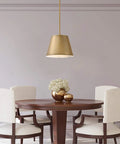 Dining area with Derose Transitional One Light Indoor Pendant Light in brushed brass finish hanging over wooden table with flowers