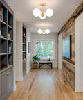 Gold 3 Light Semi Flush Mount Ceiling Light Fixture With Off White Hand Blown Glass Shade illuminates a modern hallway.