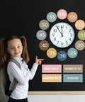 Girl pointing to Boho Rainbow Clock Numbers Bulletin Board Kit With 16 Telling Time Labels, Time Instruction Cards, On Wall