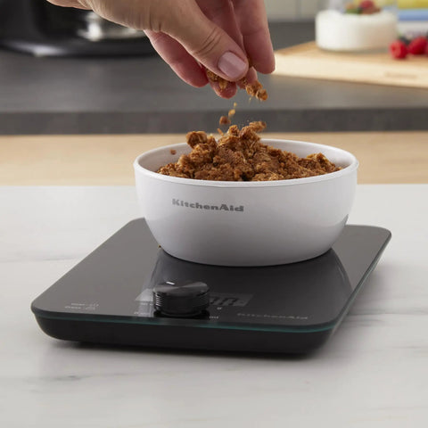 Digital Glass Top Kitchen Scale With 11 Lb Capacity in use, measuring dry ingredients in a white bowl, black finish, countertop setup.