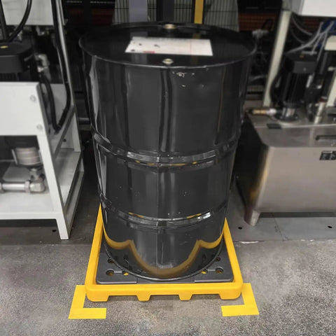 Nestable Oil Drum Spill Containment Pallet With Drain holding a black oil drum in an industrial setting