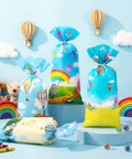 Colorful Hot Air Balloon Party Favor Bags With Ties Rainbow Cartoon Bus Theme Clear Cellophane Candy Snack Bags Includes 100 Bags And 150 Knotted Ribbons Great For Graduation Or Any Party Decor displayed with toys and rainbows.