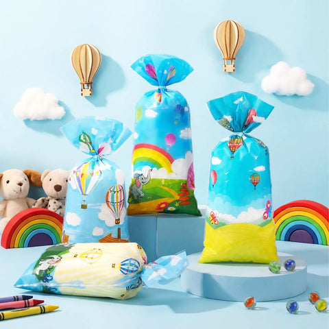 Colorful Hot Air Balloon Party Favor Bags With Ties Rainbow Cartoon Bus Theme Clear Cellophane Candy Snack Bags Includes 100 Bags And 150 Knotted Ribbons Great For Graduation Or Any Party Decor displayed with toys and rainbows.