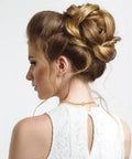 Woman with braided updo hairstyle wearing a delicate necklace.