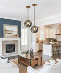 Brass Gold Globe Pendant Light with Smoke Gray Glass Shade in contemporary living room and kitchen setting.