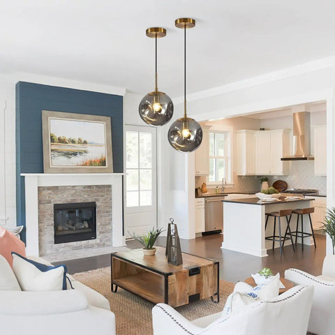 Brass Gold Globe Pendant Light with Smoke Gray Glass Shade in contemporary living room and kitchen setting.