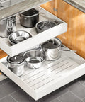 Heavy Duty Pull Out Cabinet Organizer Expands To Fit Twelve Through Twenty Inches with pots and pans in white drawers.