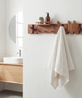 Dope Mid Century Modern Walnut Foldable Entryway Wall Coat Rack With Shelf And 9 Hooks in bathroom holding a towel