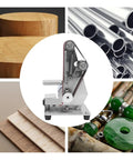Mini Electric Belt Sander And Polisher Machine Desktop Grinding Tool on workbench with wood and metal materials, compact design.