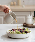 Pouring dressing from a 13oz Creamer With Handle Ceramic Pitcher For Coffee, Milk, Syrup And Sauce, Multipurpose Stoneware Jug into a salad