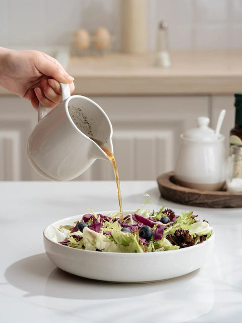 Pouring dressing from a 13oz Creamer With Handle Ceramic Pitcher For Coffee, Milk, Syrup And Sauce, Multipurpose Stoneware Jug into a salad