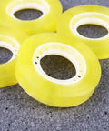 Dope 12 Pack 11mm x 30m BOPP Packing Tape in yellow, ideal for packaging and school use, displayed against a gray background