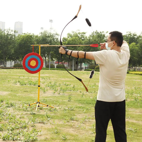 Man aiming at Backyard Archery Target For Adults And Youth, Easy Arrow Removal And Durable Straw Target For Outdoor Practice