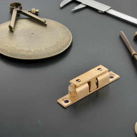 Copper Ball Catch Door Latch Set For Boats And Yachts on a black background with measuring tools