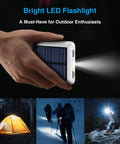 Pocket Sized Solar Power Bank 12000mAh with Built In Cables and Dual USB Outputs, shown with LED flashlight, used in outdoor settings.