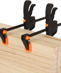 4 Inch Bar Clamps For Woodworking 8 Pack Quick Grip One Handed Ratchet Clamps securing wooden boards in a DIY carpentry setup