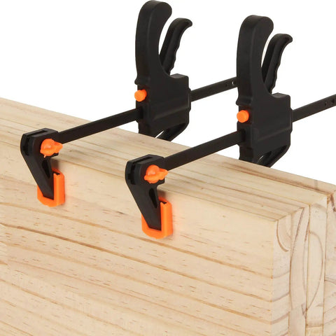 4 Inch Bar Clamps For Woodworking 8 Pack Quick Grip One Handed Ratchet Clamps securing wooden boards in a DIY carpentry setup