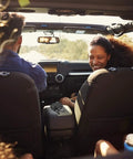 View from backseat of car with two people, focus on Mini Carry Case For Bluetooth Pro OBDII OBD2 Scan Tool on console.