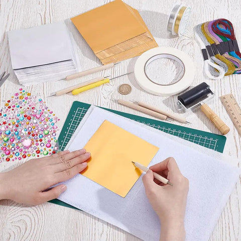 Metal Embossing Kit 51 Pcs for DIY Art Projects with Aluminum Foil Sheets 12x12cm and tools on a table