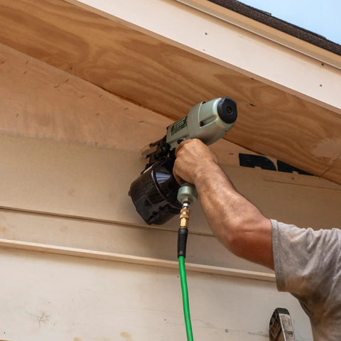 Person using Two And A Half Inch Coil Siding Nailer Pro Bundle With Bonus 18V Triple Hammer Impact Driver Kit on siding installation