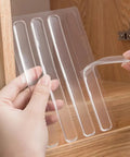 Hands holding and peeling off a clear silicone strip from a set of 100Pcs Self Adhesive Rubber Bumper Strips For Door Slam Prevention.