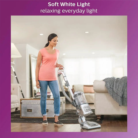 Woman vacuuming living room with soft white light, showcasing EyeComfort LED A19 4 Pack Soft White 2700K 450 Lumens Frosted Flicker Free Bulbs.