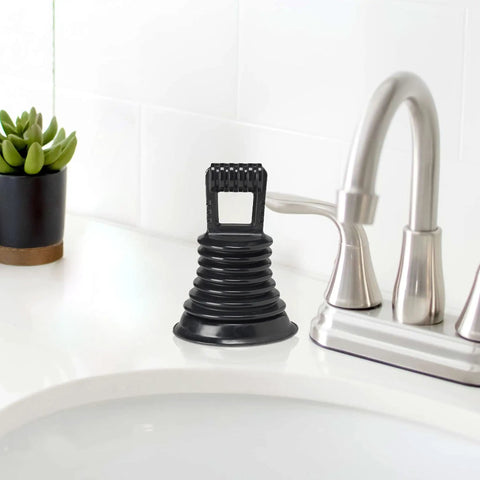 Must Have Mini Bellows Sink Plunger For Kitchens Bathrooms Baths Laundry Tubs And RVs Compact Powerful Clog Clearing Tool With Rubber Cup Easy To Store Portable Great For Quick Drains next to a faucet on a white countertop