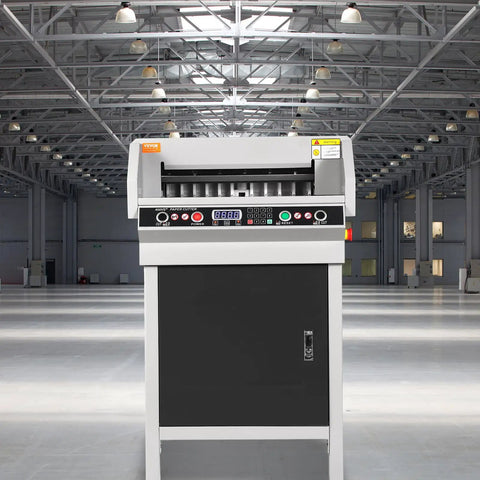 VEVOR Heavy Duty Electric Hydraulic Paper Cutter 18 Inch Cutting Width With Four Inch Thick Capacity Industrial Paper Trimmer Machine Featuring Button Control For Precision Cuts And Sturdy Metal Construction in a large industrial space.