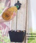 Heavy Wall Mounted Beer Bottle Opener With Slick Stainless Steel Cap Catcher Bucket Rustproof Black Cast Iron Finish. User opening beer.