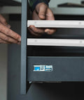 Installation of Rock Solid 12 Inch Side Mounted Plastic Drawer Slides In Crisp White, showcasing smooth gliding in cabinet.