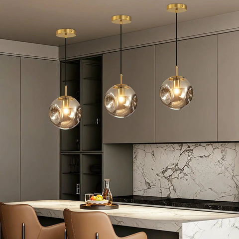 Modern Smoke Gray Glass Globe Pendant Light 3 Pack, 7.87" Hardwired Brass Pendant with Adjustable 59" Cord above kitchen island.