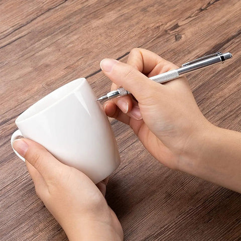 Person using Top Tier Two Pack Tungsten Carbide Scribe Pens to mark on a white mug with a strong grip.