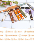 Variety pack of colorful faux leather drawer pulls arranged in fan shape, featuring light coffee, each with single hole and gold accents.