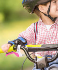 Child riding bike with Kids Bike Brake Lever Set, 2 Pack Universal Brake Handles For Kids Bikes in rosy color installed.