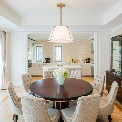 16" White and Gold Drum Pendant Light with Metal Lantern Fabric Shade over a round dining table in a modern kitchen.
