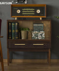 Vintage wooden cabinet with a retro radio on top, books, and decorative boxes in a mid-century modern styled room.