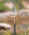 Three Arm High Rise Sprinkler With Telescoping Base For Mid Sized Yard Coverage shown in operation, brass construction