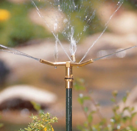 Three Arm High Rise Sprinkler With Telescoping Base For Mid Sized Yard Coverage shown in operation, brass construction