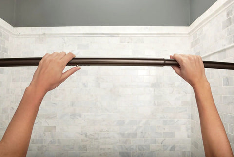 Hands adjusting Curved Tension Shower Curtain Rod With Pivoting Flanges No Drill Installation Old World Bronze Finish