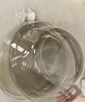 Grippy Wall Mount Hook With Heavy Duty Adhesive Strip No Stress Drilling Required holding a clear bowl on tile wall.