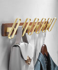 Heavy Duty Solid Wood Double Coat Hook With Sleek Brushed Gold Finish Wall Mounted Robe Rack holding bags and jackets.