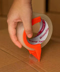 Person using dispenser with heavy duty packing tape for shipping and moving, 1.88 inch wide by 65 yards per roll, showing strong hold.
