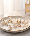 8Pcs Pearl Waist Tightener Pins For Jeans And Skirts Skip The Belt Instant Cinch Clips With Durable Alloy Frame Decorative Gap Eliminator displayed elegantly on a white plate.