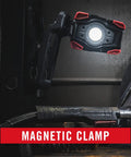 Rechargeable Dual Power LED Work Light With Magnetic Clamp, black red light clamped to metal surface, illuminating workspace