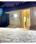 Heavy Duty Solar Led Flood Light With Remote Control illuminating a building entrance at night for security.
