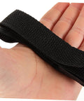 Close-up of a black strap from the Eight-Piece Adjustable Lawn Aerator Shoes Straps for Garden Spiked Sandals on a hand.