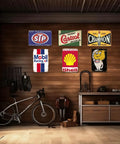 Kickass Vintage Metal Tin Signs Set Of Six Retro Garage Wall Decor Featuring Distressed Oil And Gas Station Prints For Awesome Man Cave Badass Automotive Wall Art, displayed on wooden wall in garage.